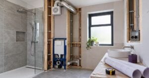 Bathroom renovation in progress with plumbing, ventilation and electrical services visible