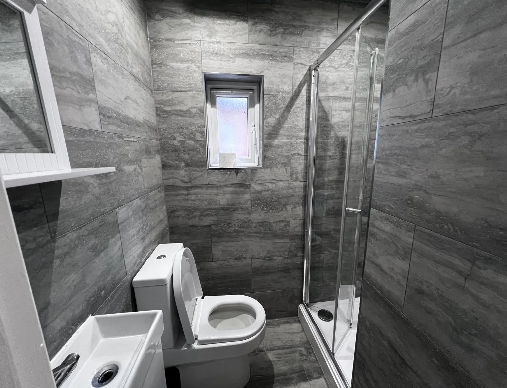 Tiled en-suite shower room with basin, WC and shower enclosure