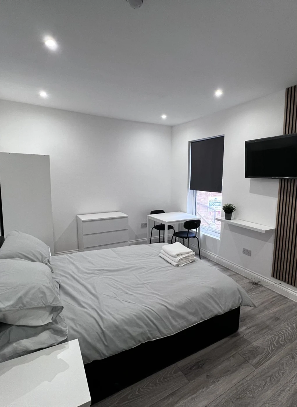 Finished bedroom at The Warren with dining space and wall-mounted television